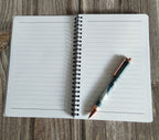 Open notebook with a pen on a wooden surface