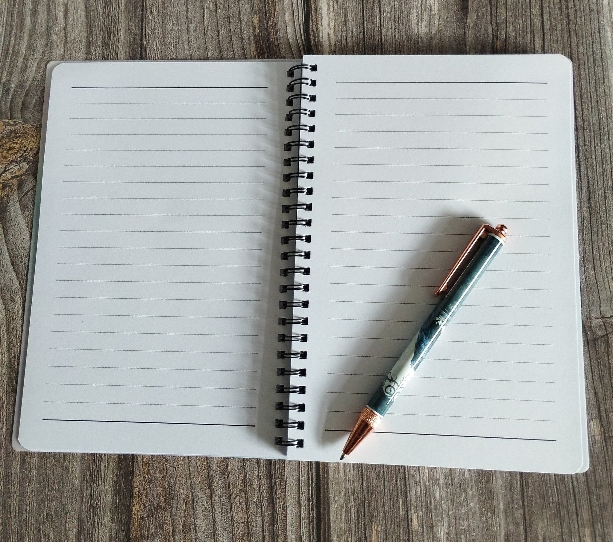 Open notebook with a pen on a wooden surface