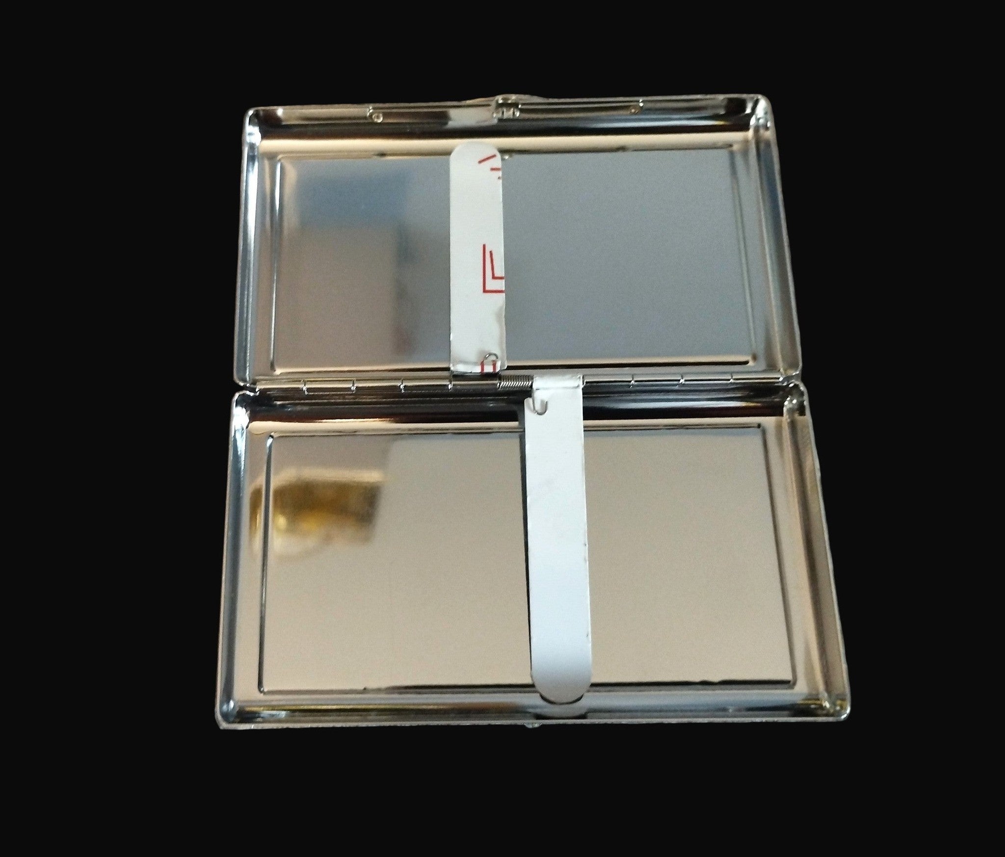 Cigarette casewith two reflective surfaces on a wooden surface