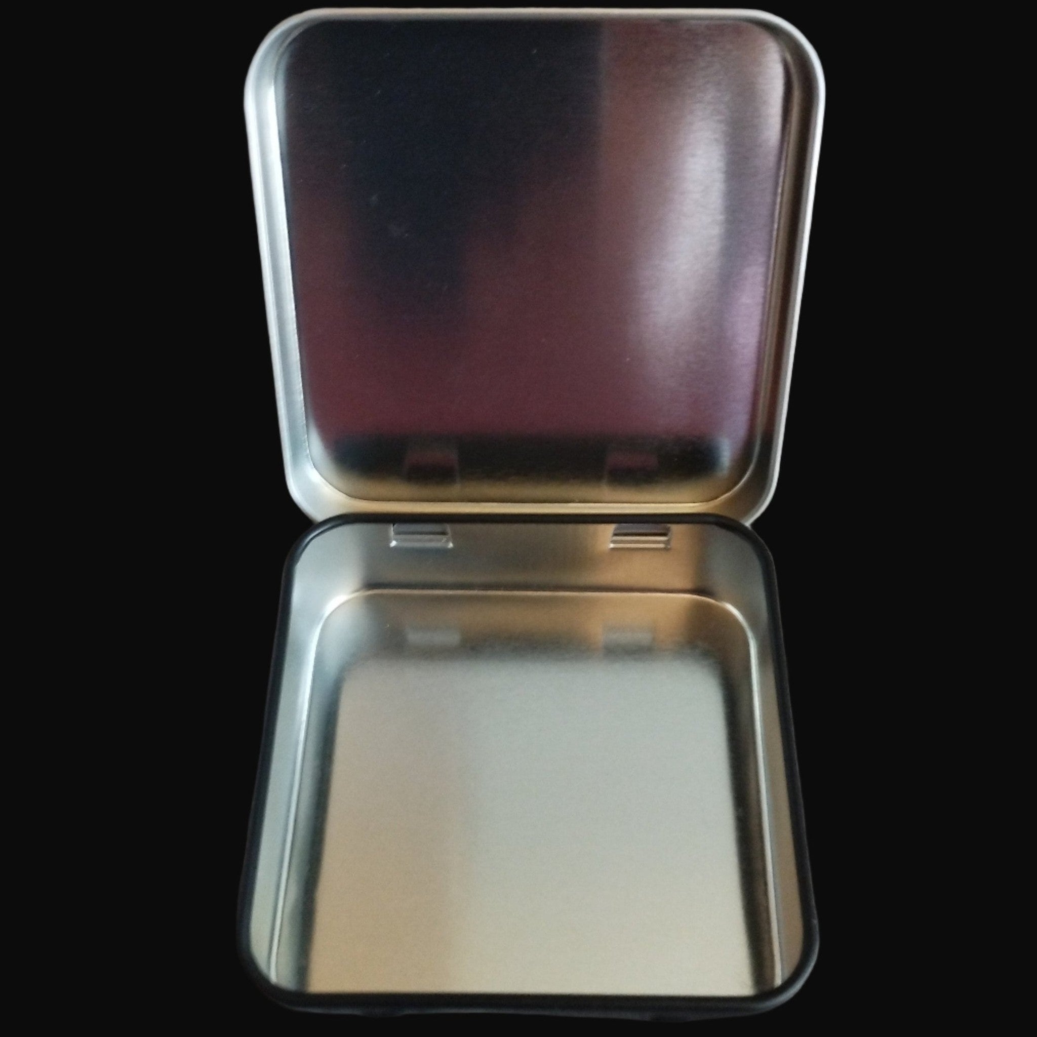 Metallic tin with a lid on a black surface