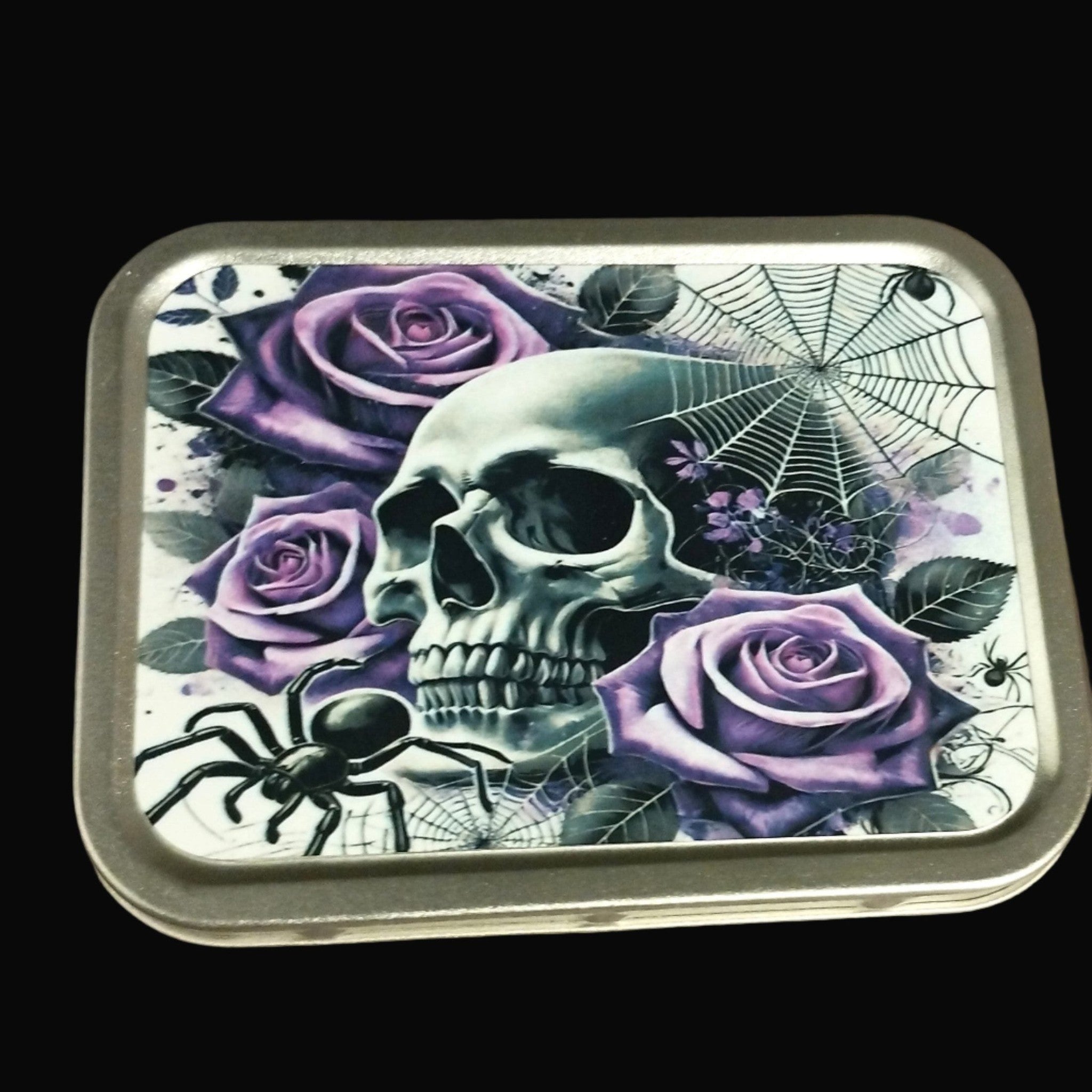 Decorative tin with skull and purple roses design on a wooden surface