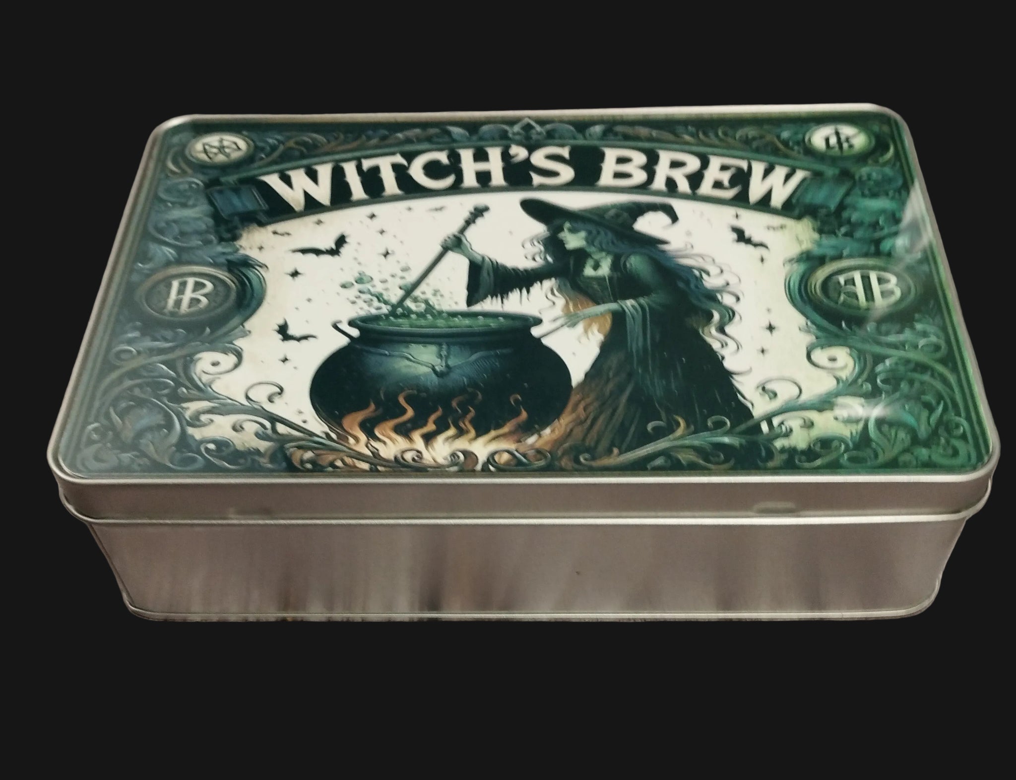 Tin box with 'Witch's Brew' design featuring a witch and cauldron on a wooden surface.