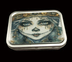 Decorative tin box with artistic design on a wooden surface