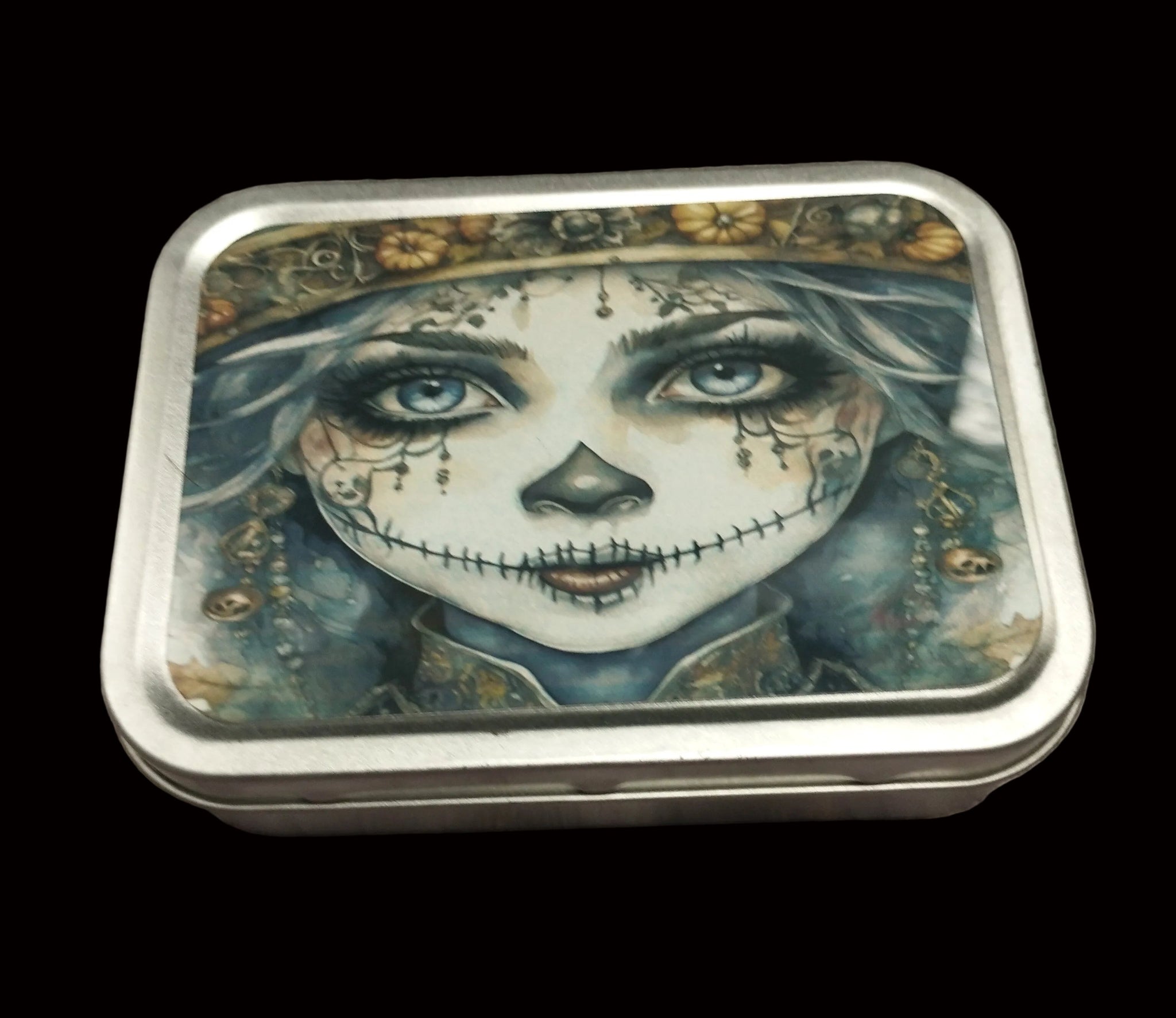 Decorative tin box with artistic design on a wooden surface