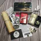 Collection of themed items including a hat tin, candle, keychain, and other decorative pieces on a wooden surface.