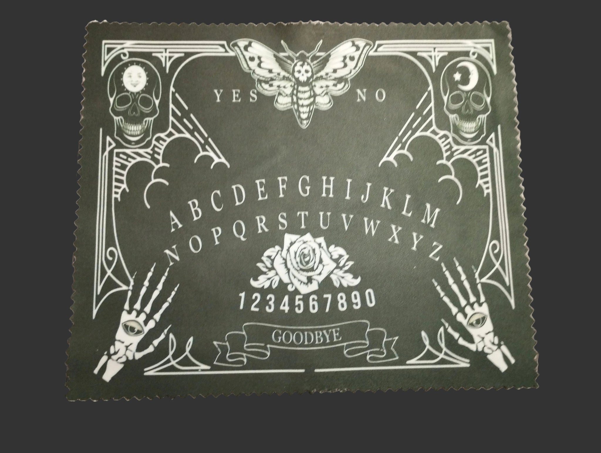 Ouija board design lens cloth on a wooden surface