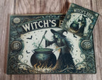 Decorative mat with witch design and 'Witch's Brew' text on a wooden surface