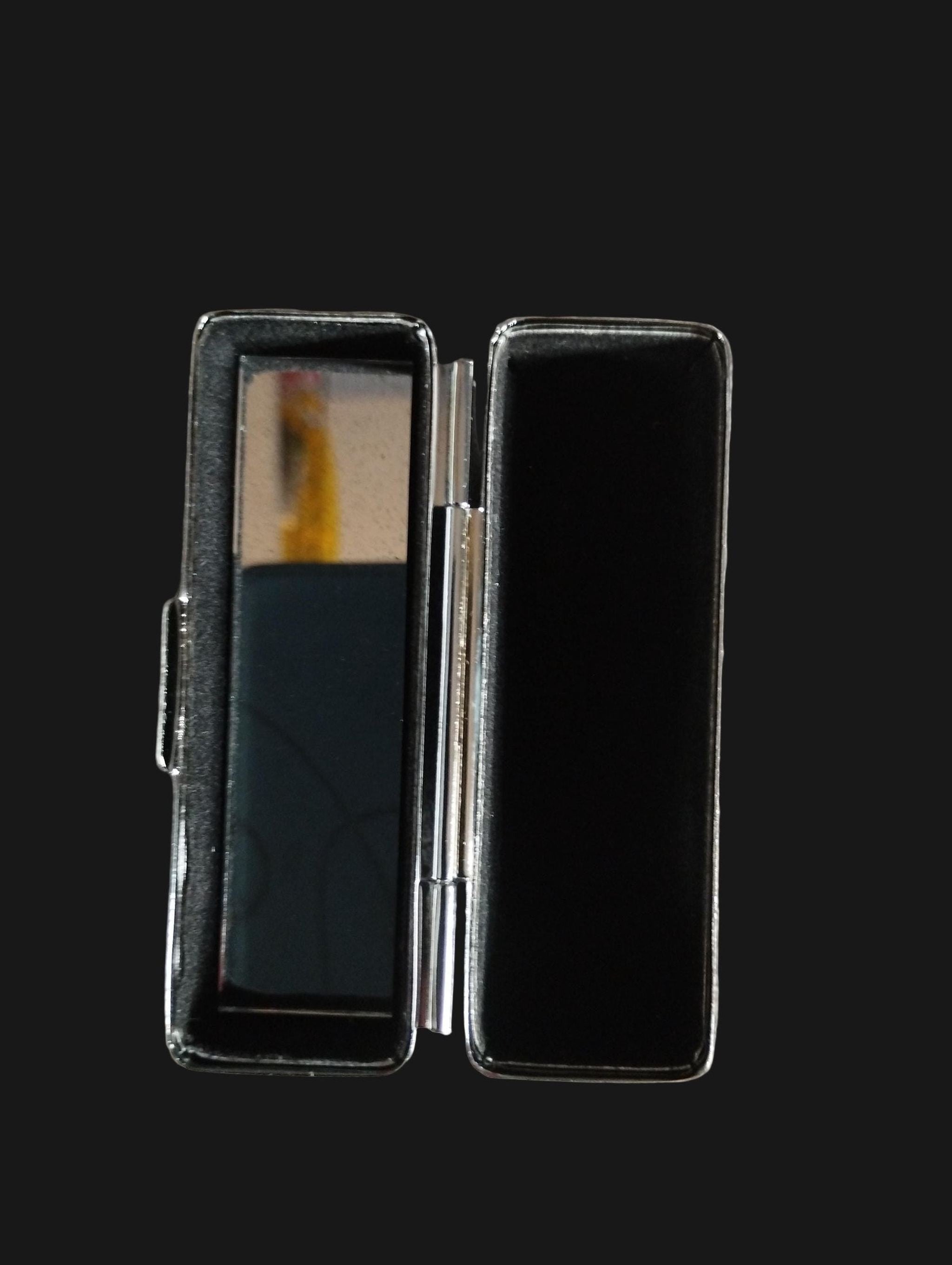 Black rectangular object with a reflective surface on a wooden surface
