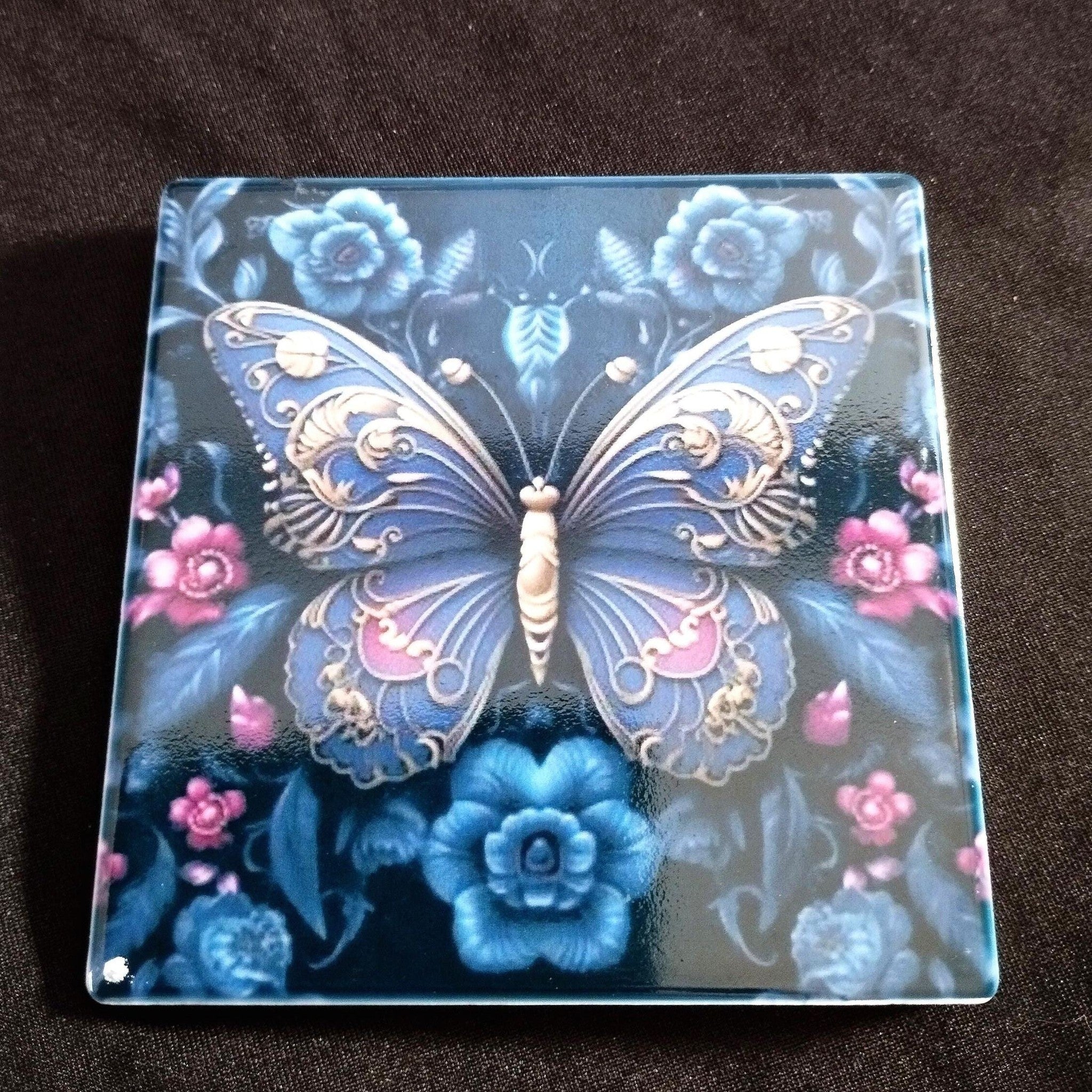Decorative square piece with a butterfly and floral design on a dark background