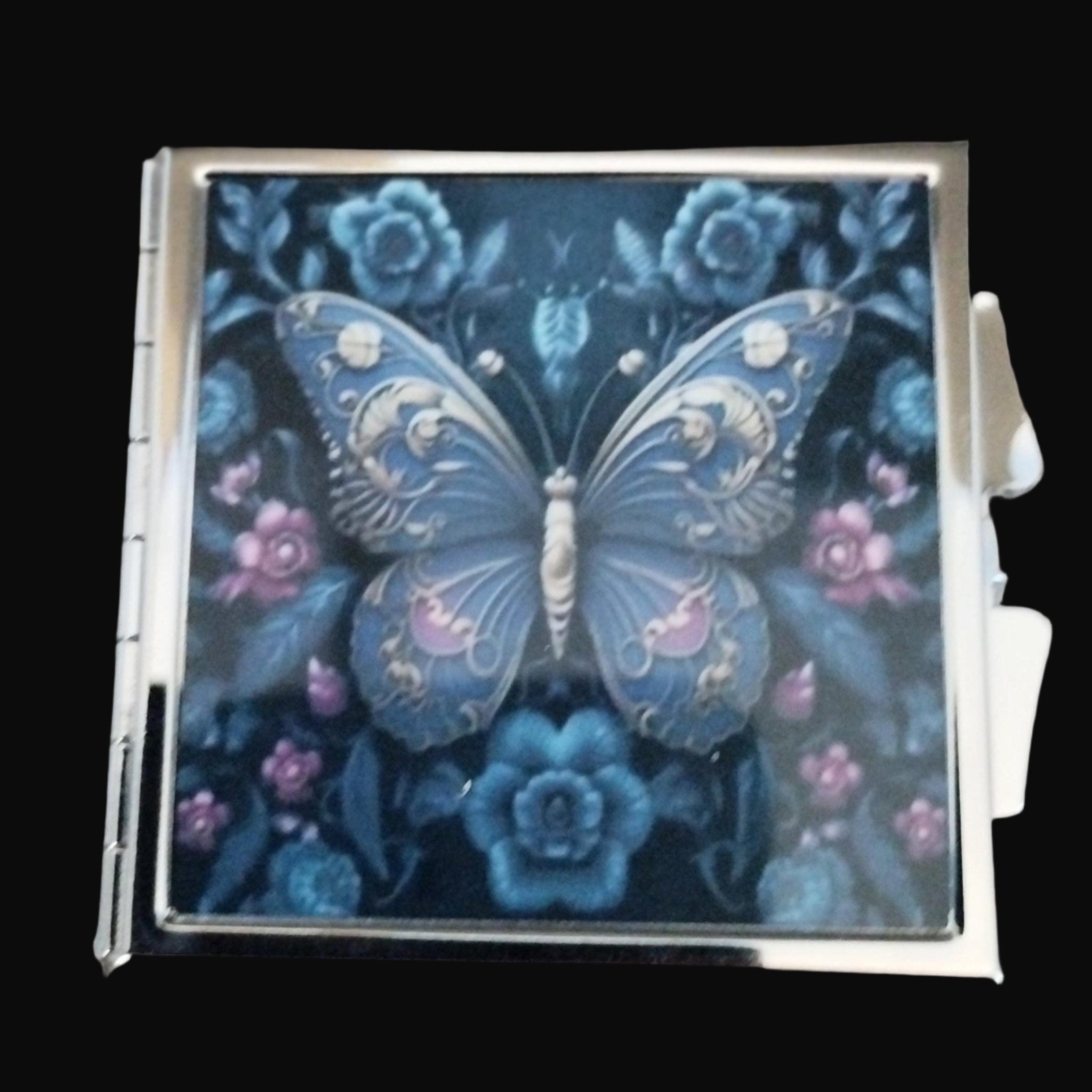 Decorative card with a blue butterfly and floral design on a wooden surface