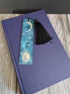 Decorative bookmark with celestial design on a purple notebook