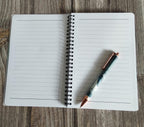 Open notebook with a pen on a wooden surface