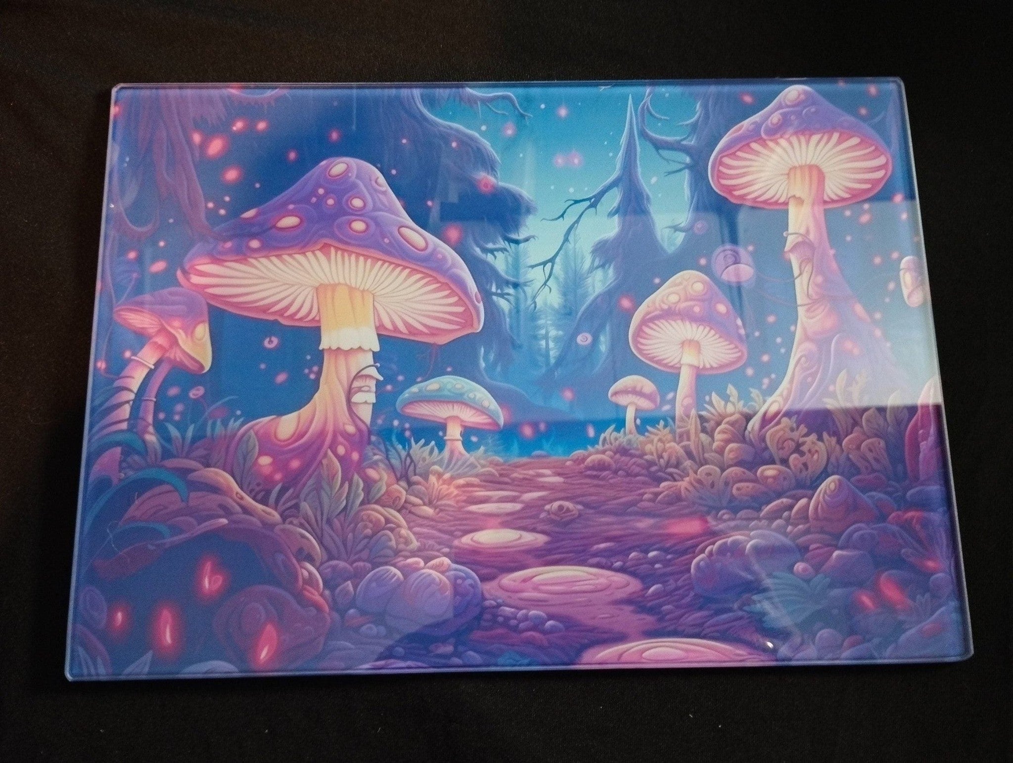 Colorful mushroom forest design on a clear plastic sheet against a black background