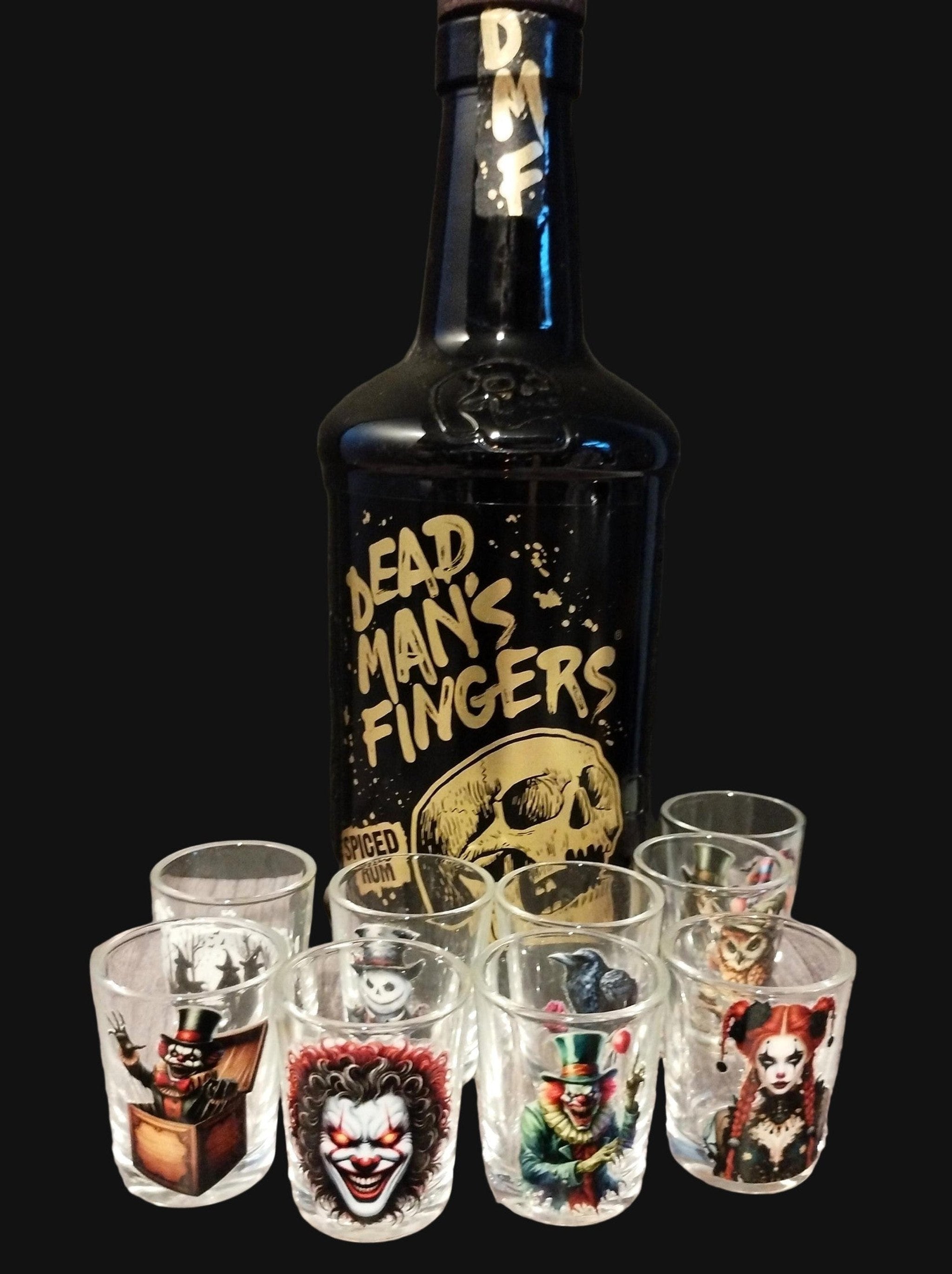 Bottle of Dead Man's Fingers rum with shot glasses featuring various designs on a wooden surface.