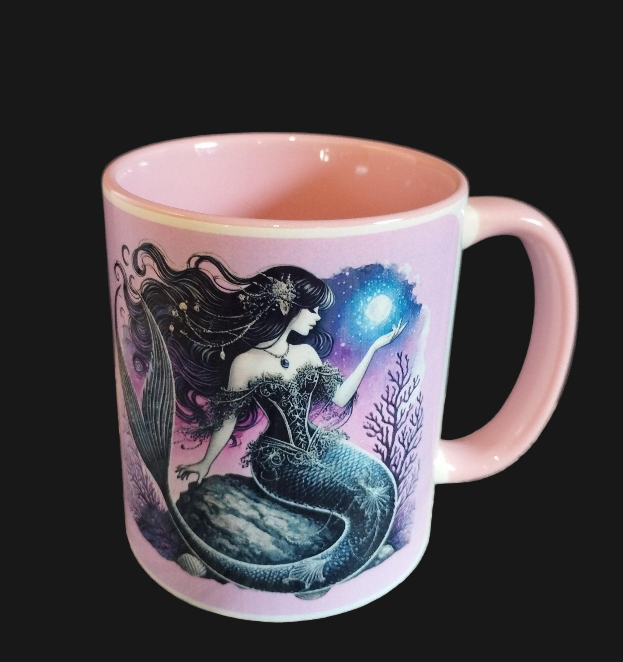 Pink mug with mermaid design on a wooden surface