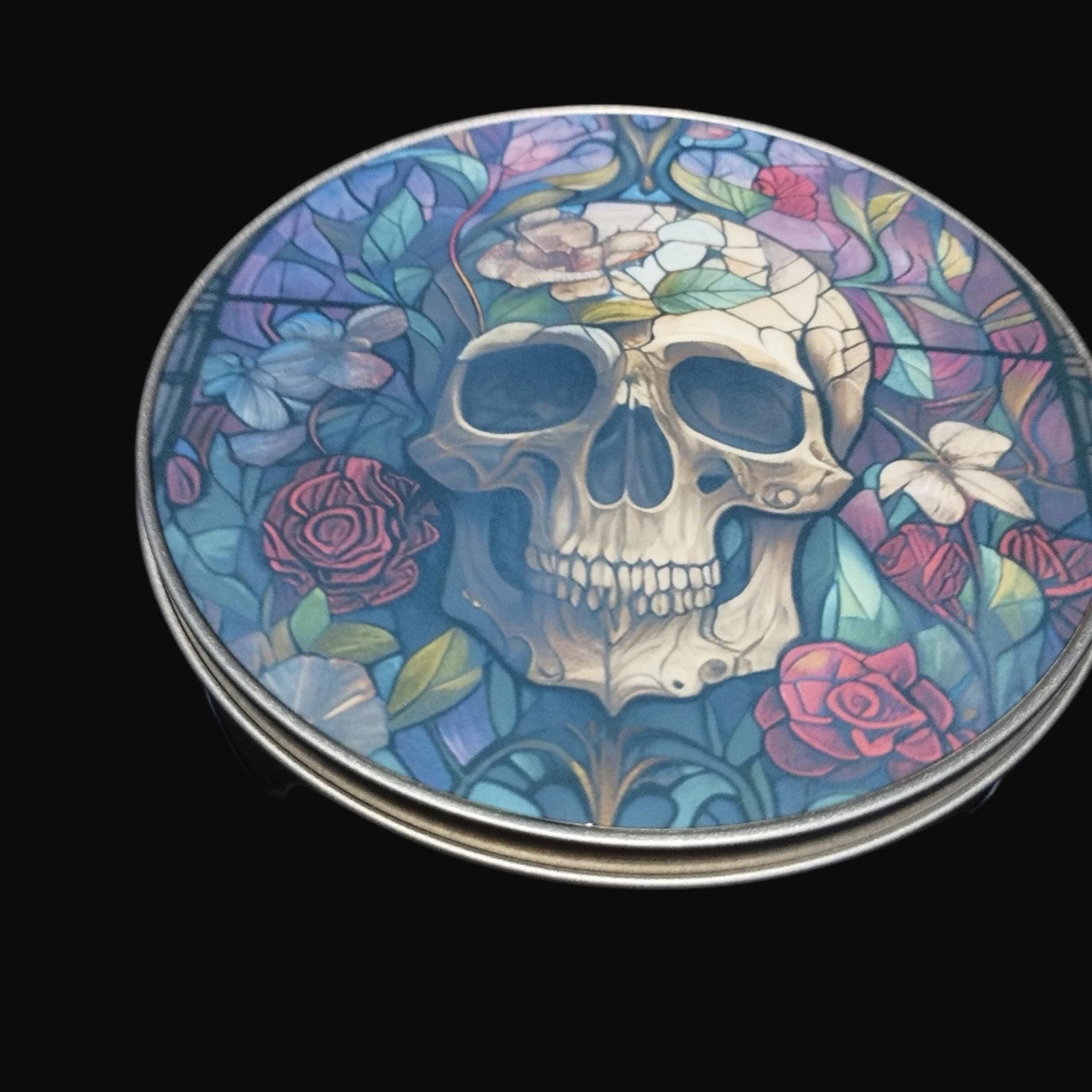 Decorative coaster with a skull and floral design on a black background