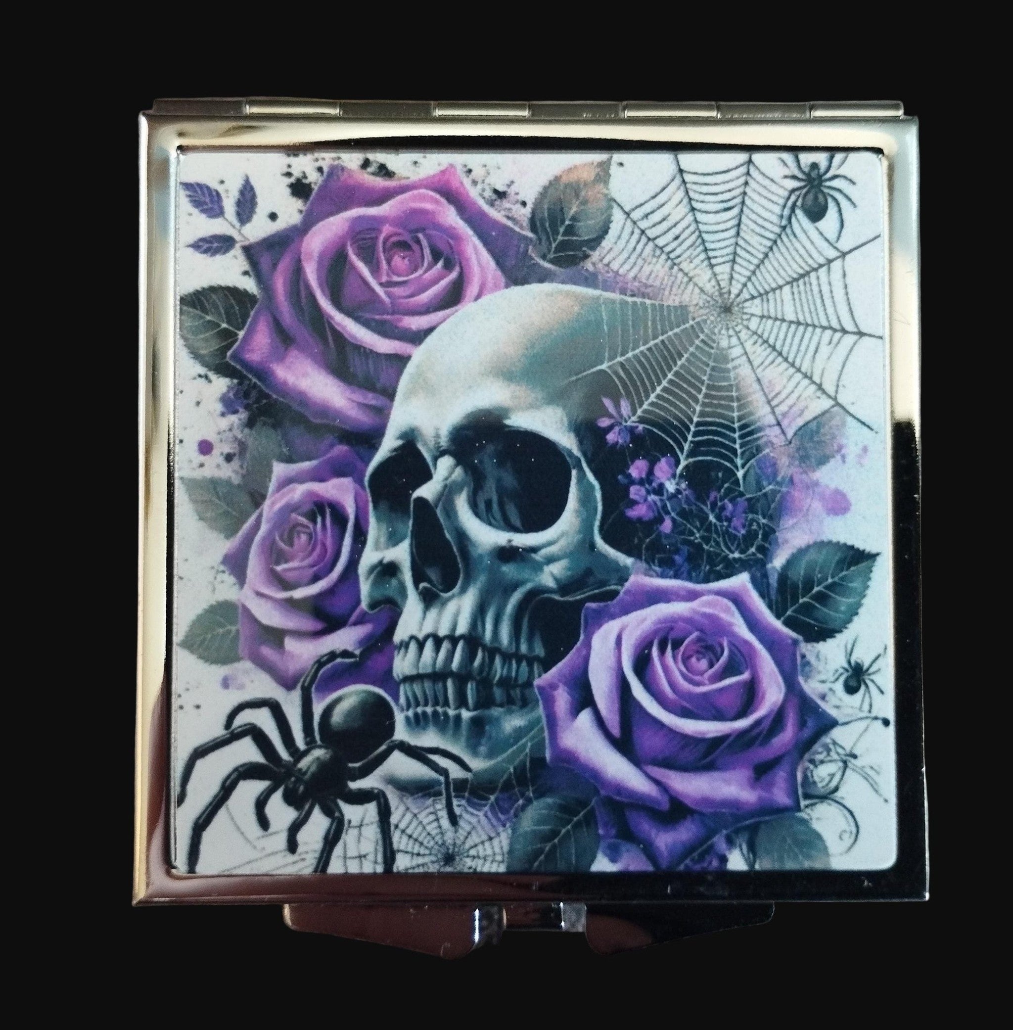 Compact mirror with skull and purple roses design on a wooden surface