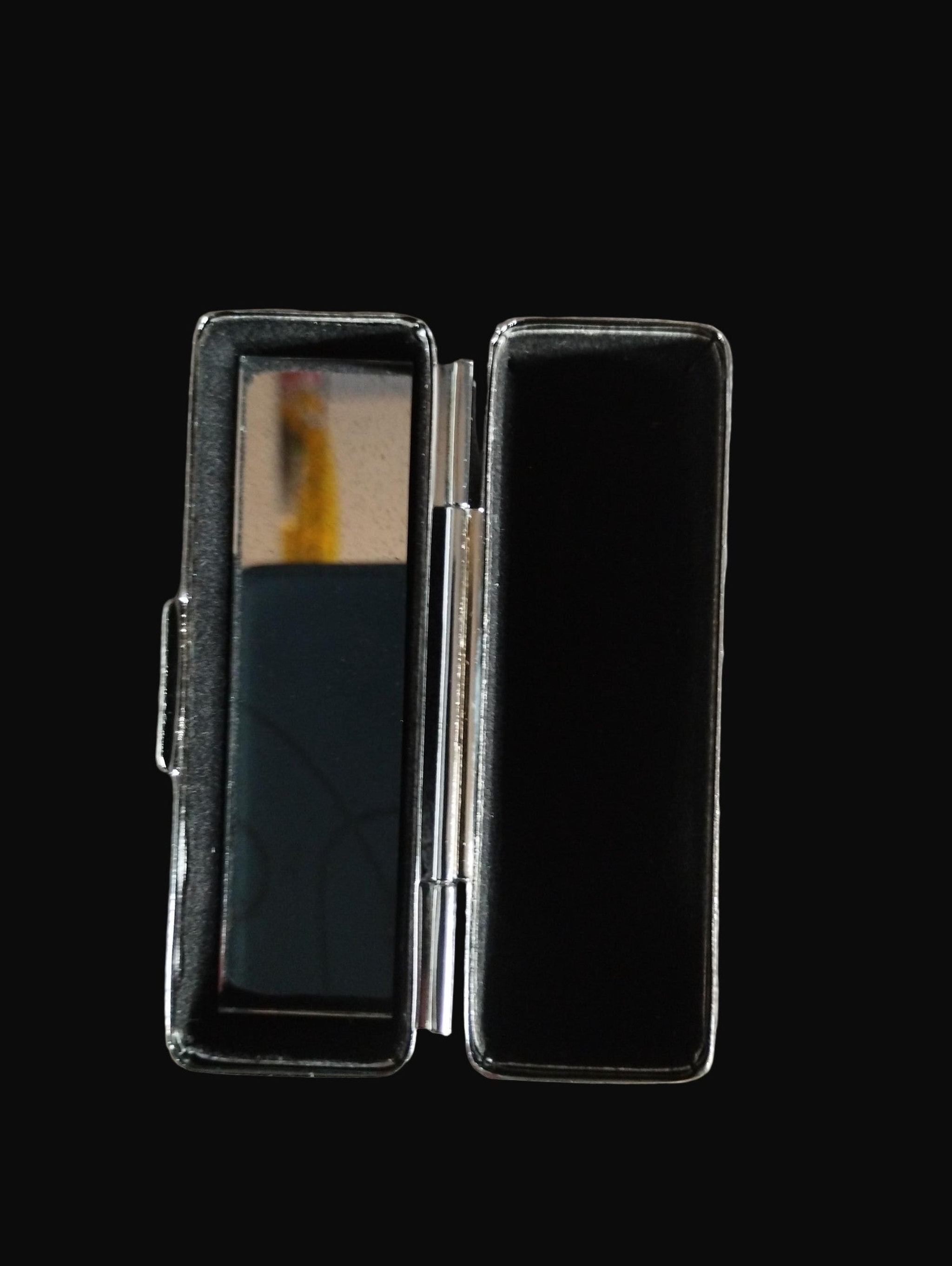 Black compact mirror on a wooden surface