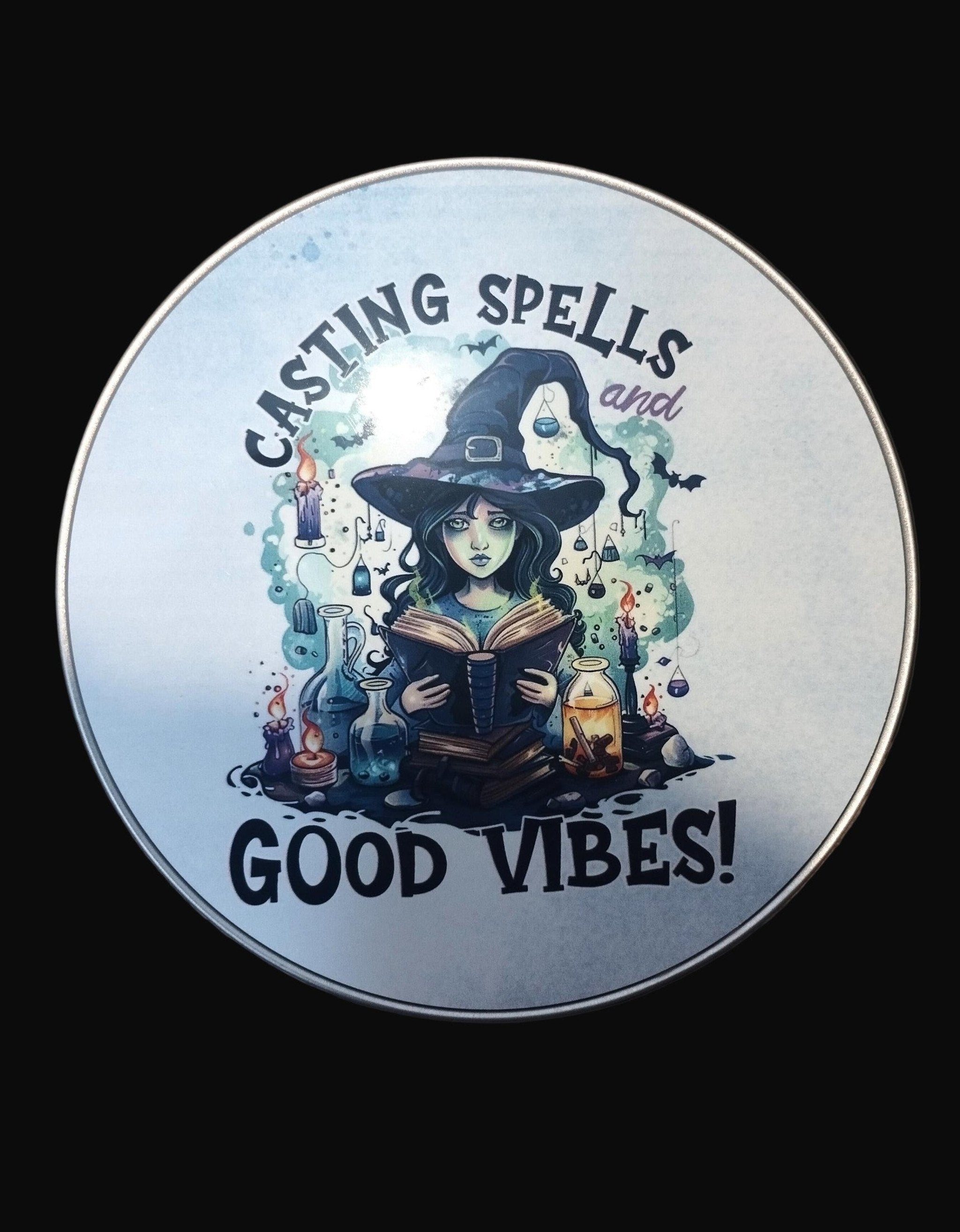 Circular sign with a witch holding a book and text 'Casting Spells and Good Vibes' on a dark background.
