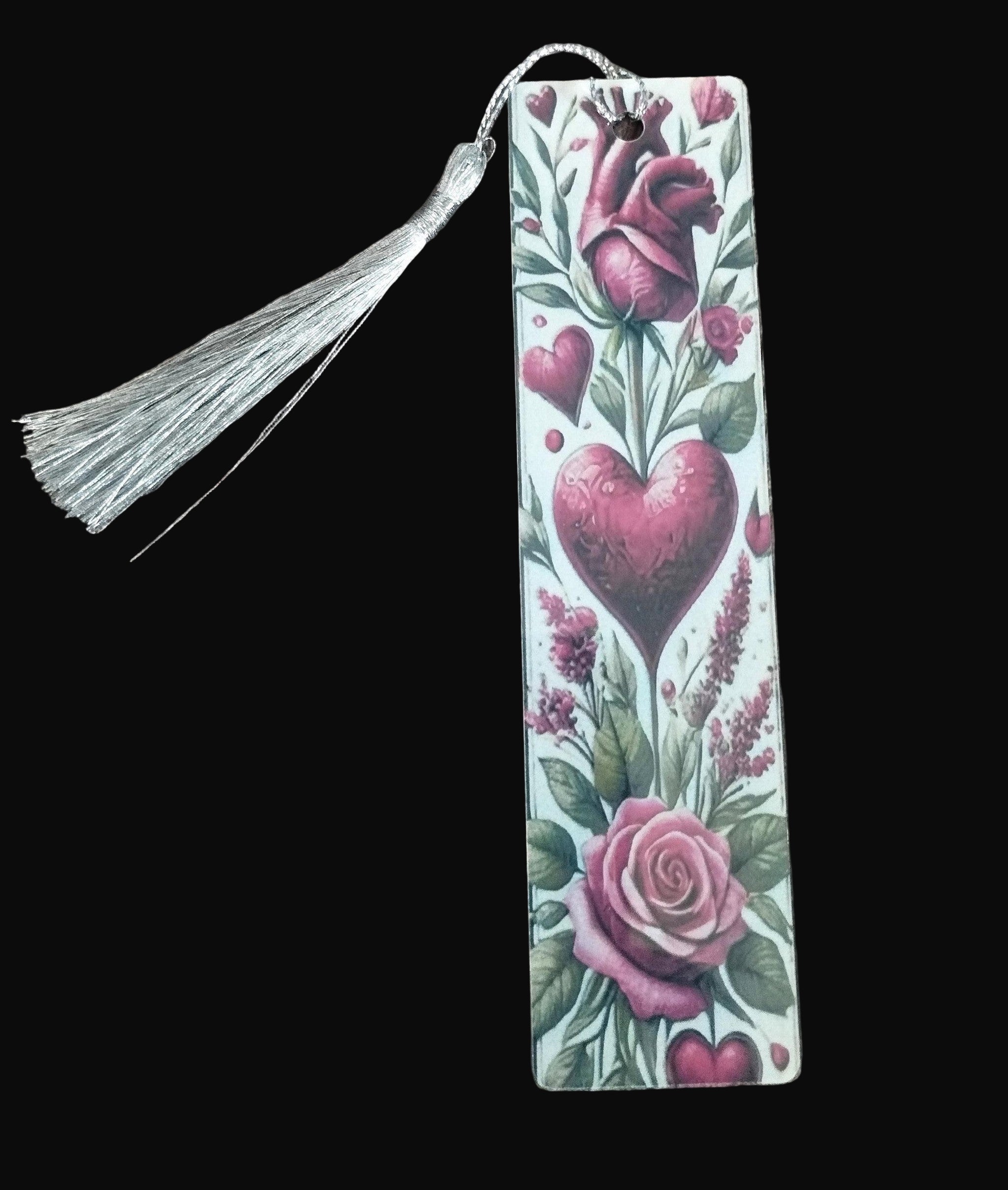Decorative bookmark with floral design and tassel on a wooden surface
