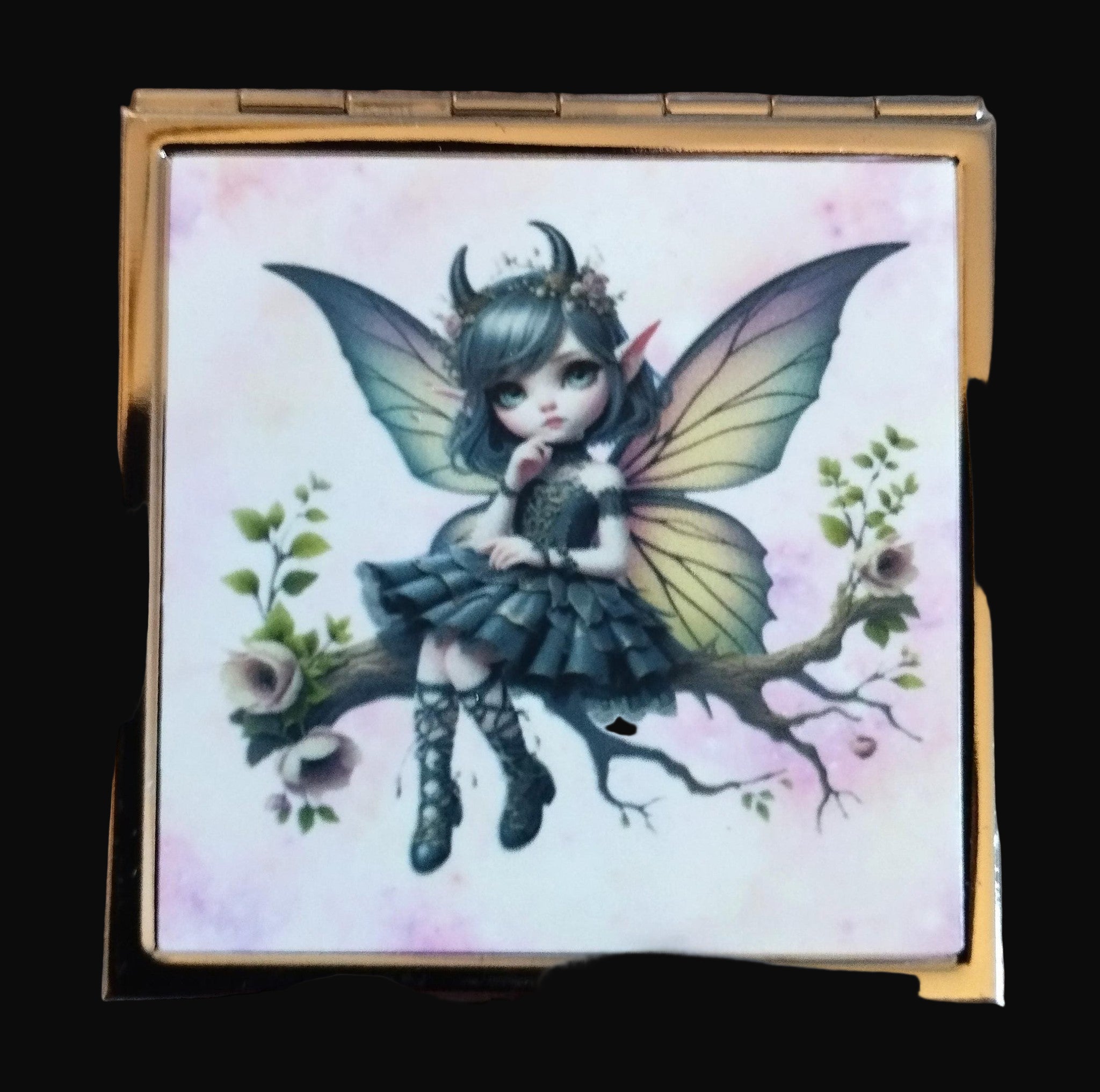 Compact mirror with a fairy design on a wooden surface