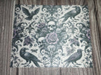 Decorative paper with raven and skull design on a wooden surface