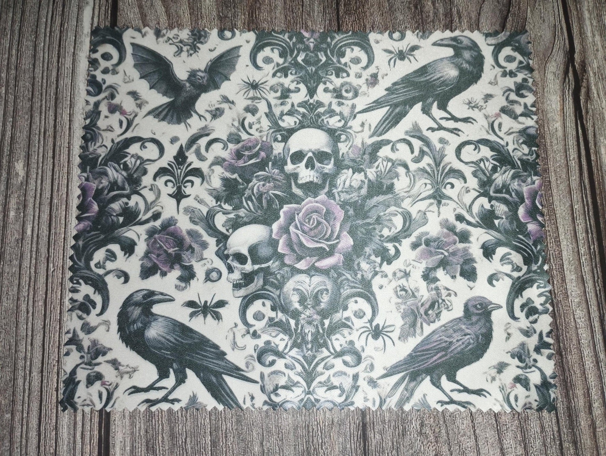 Decorative paper with raven and skull design on a wooden surface