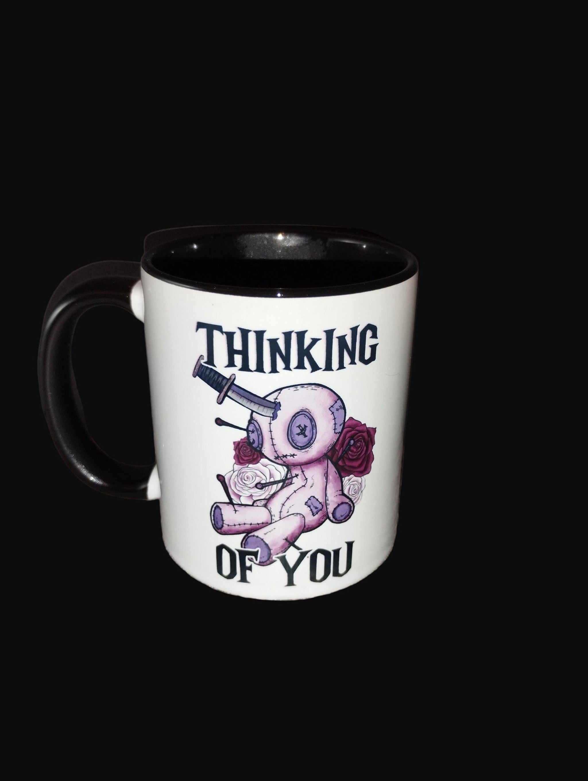 Mug with a design and text 'Thinking of You' on a wooden surface.