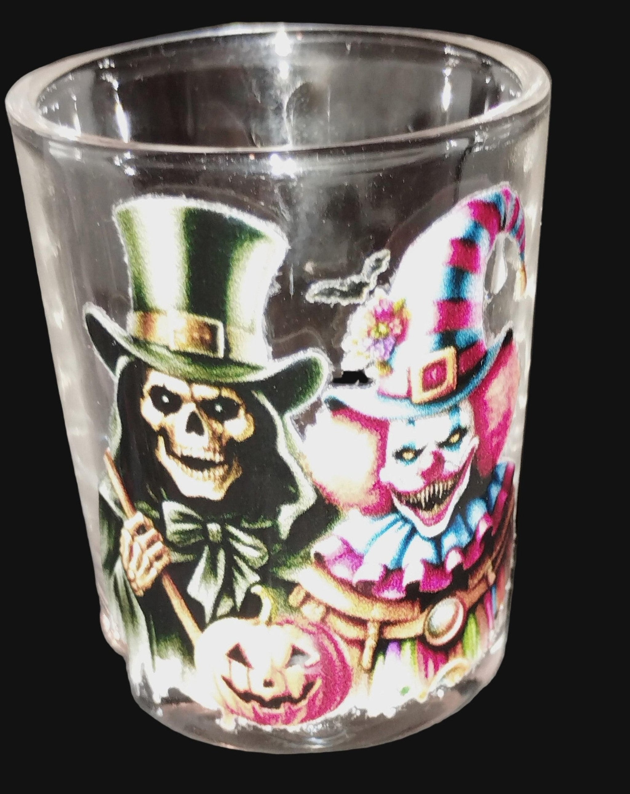 Glass with Halloween-themed design of a skeleton and clown.