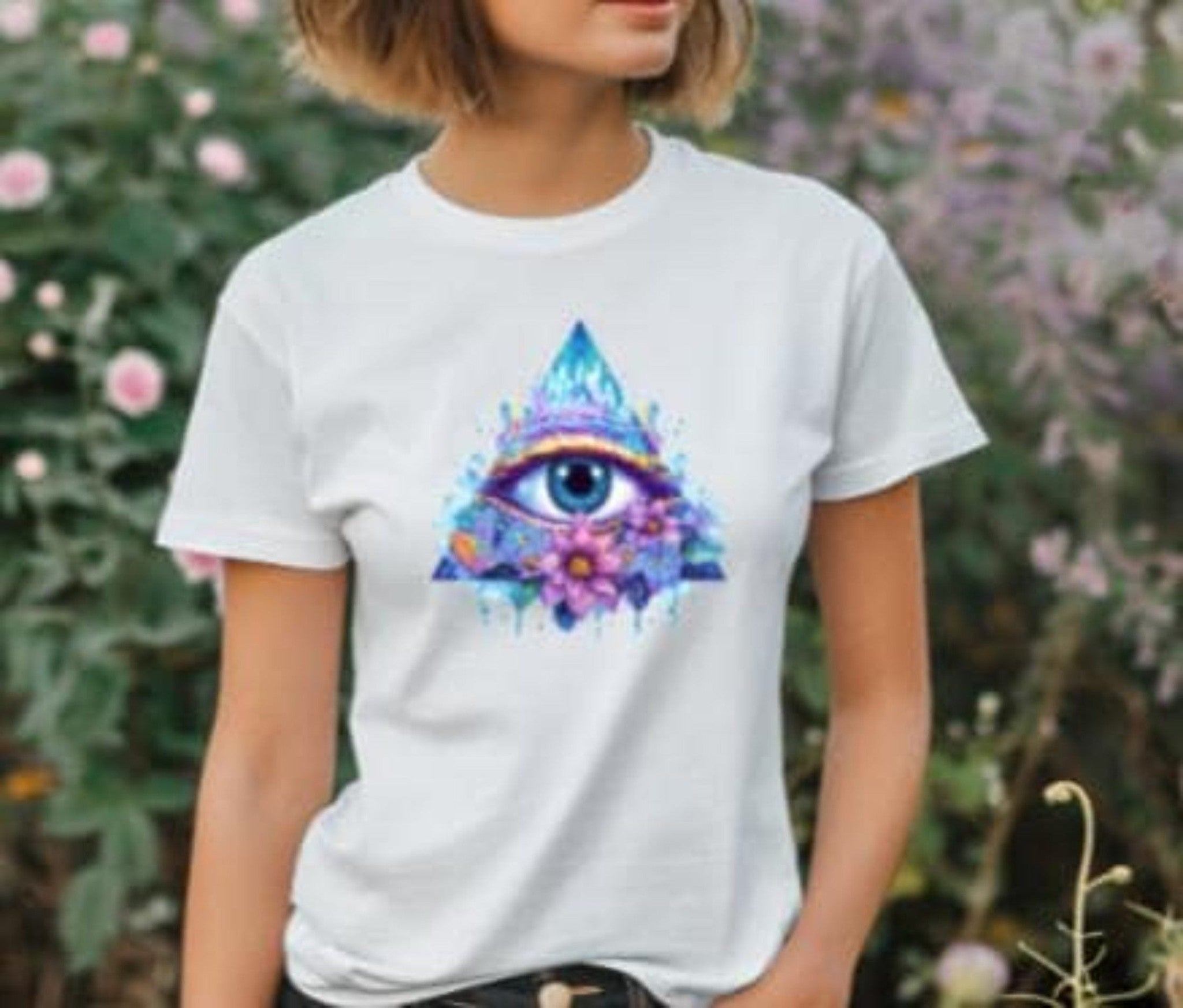 Person wearing a white t-shirt with a colorful eye design in front of a floral background