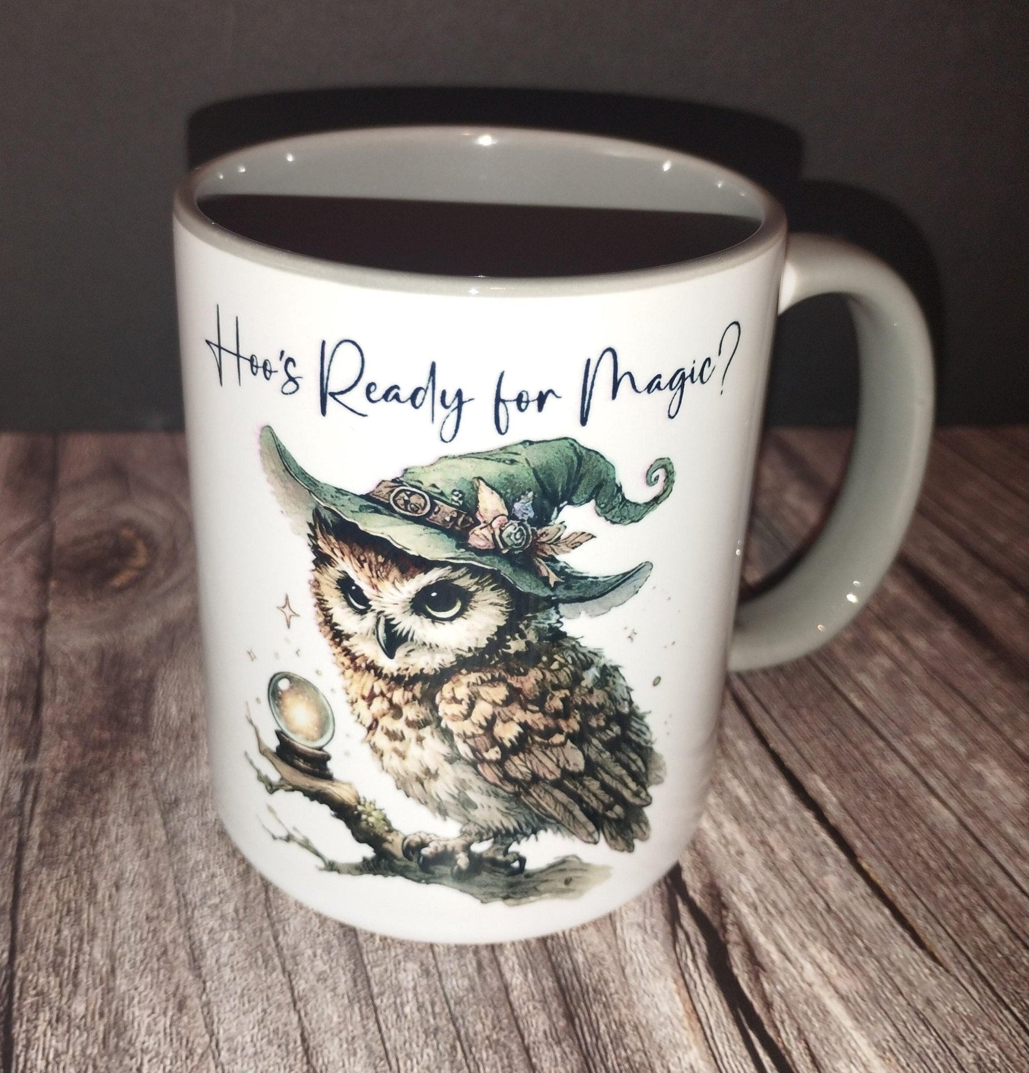 Mug with owl design and text 'Who's Ready for Magic?' on a wooden surface