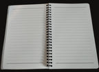 Open notebook with lined pages on a wooden surface