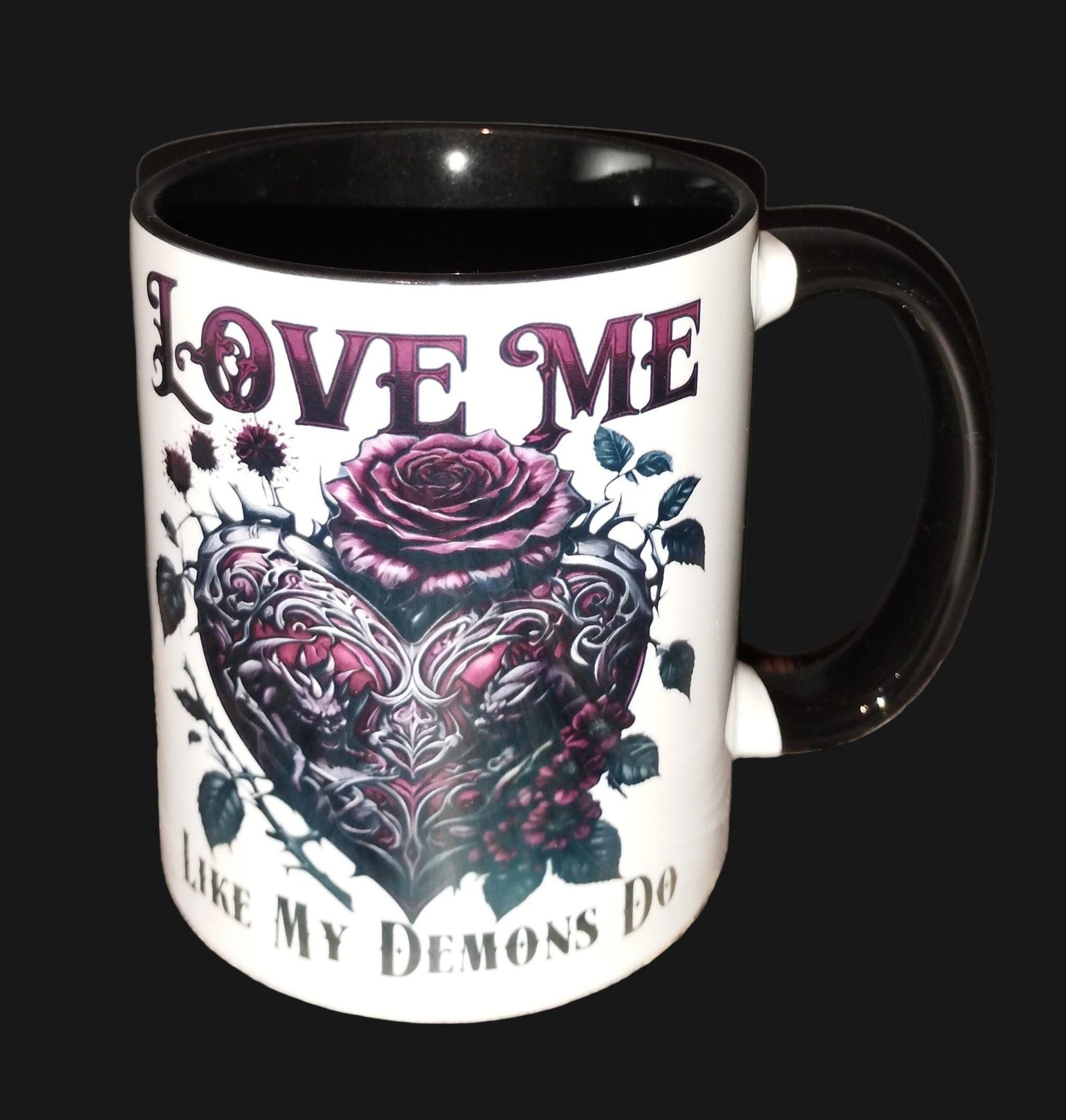 Mug with heart design and text 'Love me like my demons do' on a wooden surface.