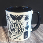 Mug with 'Stay Weird' design on a wooden surface