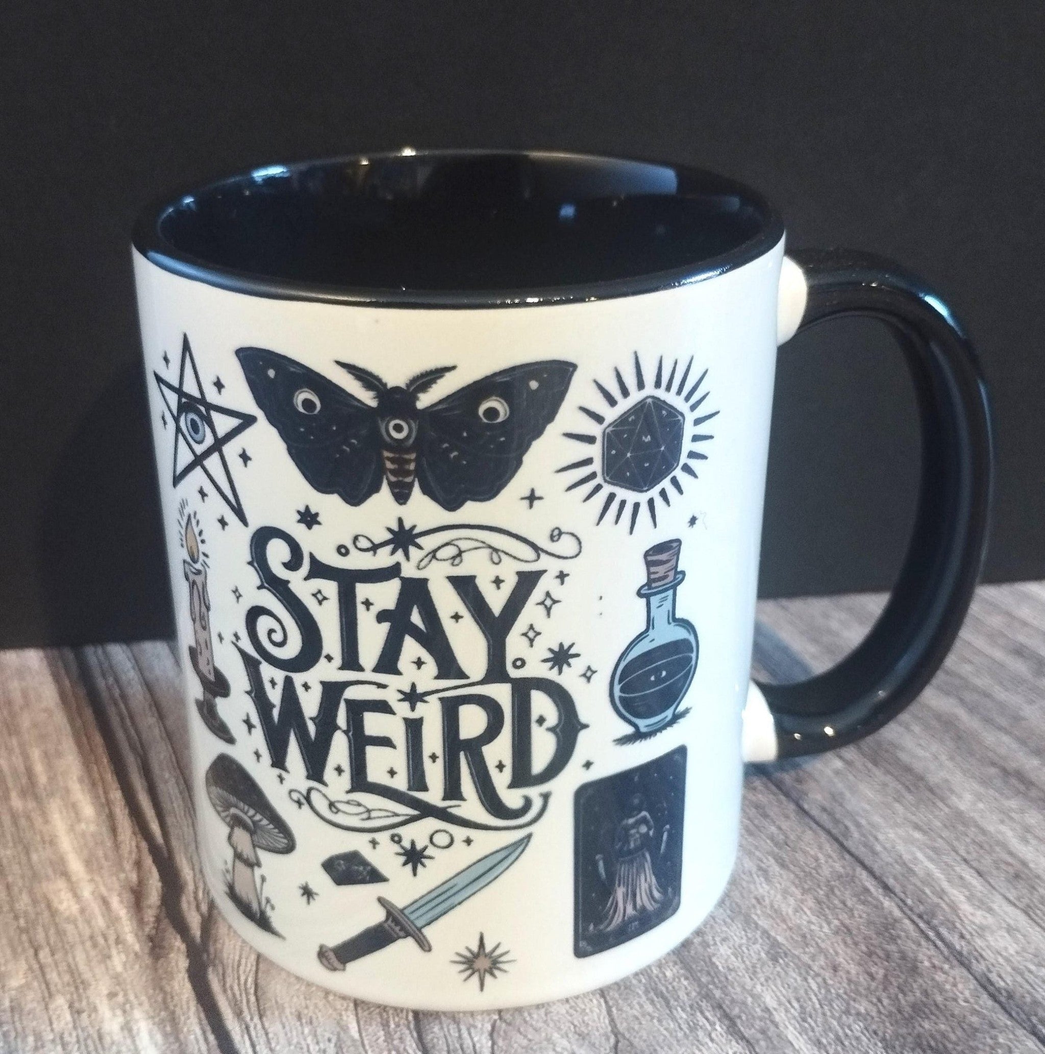 Mug with 'Stay Weird' design on a wooden surface