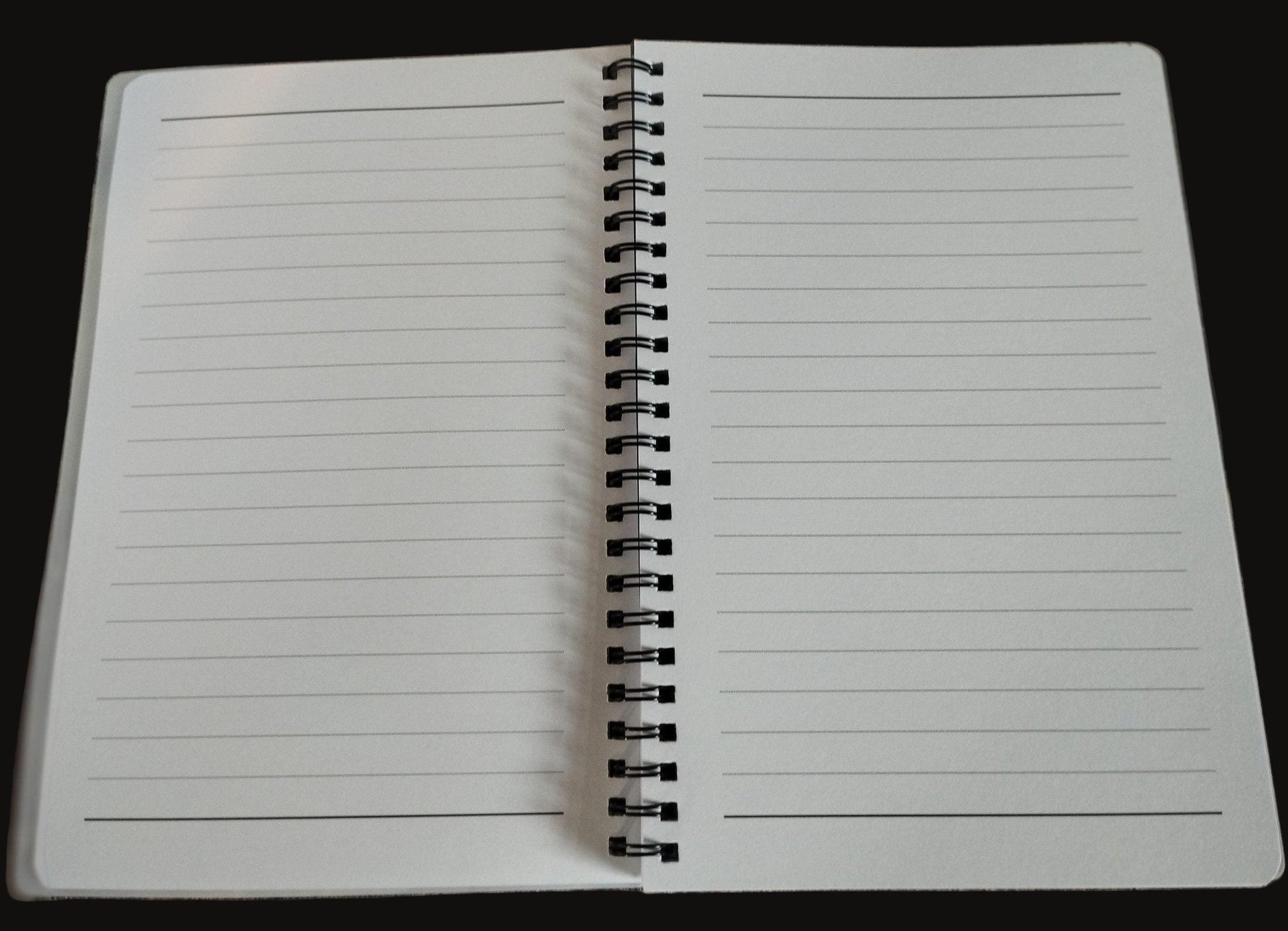Open notebook with lined pages on a wooden surface