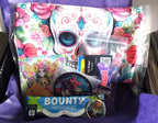 Colorful skull-themed product with 'Bounty' hot chocolate packaging on a purple surface.