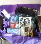Collection of items including cards, a small bag, and other decorative objects on purple tissue paper.