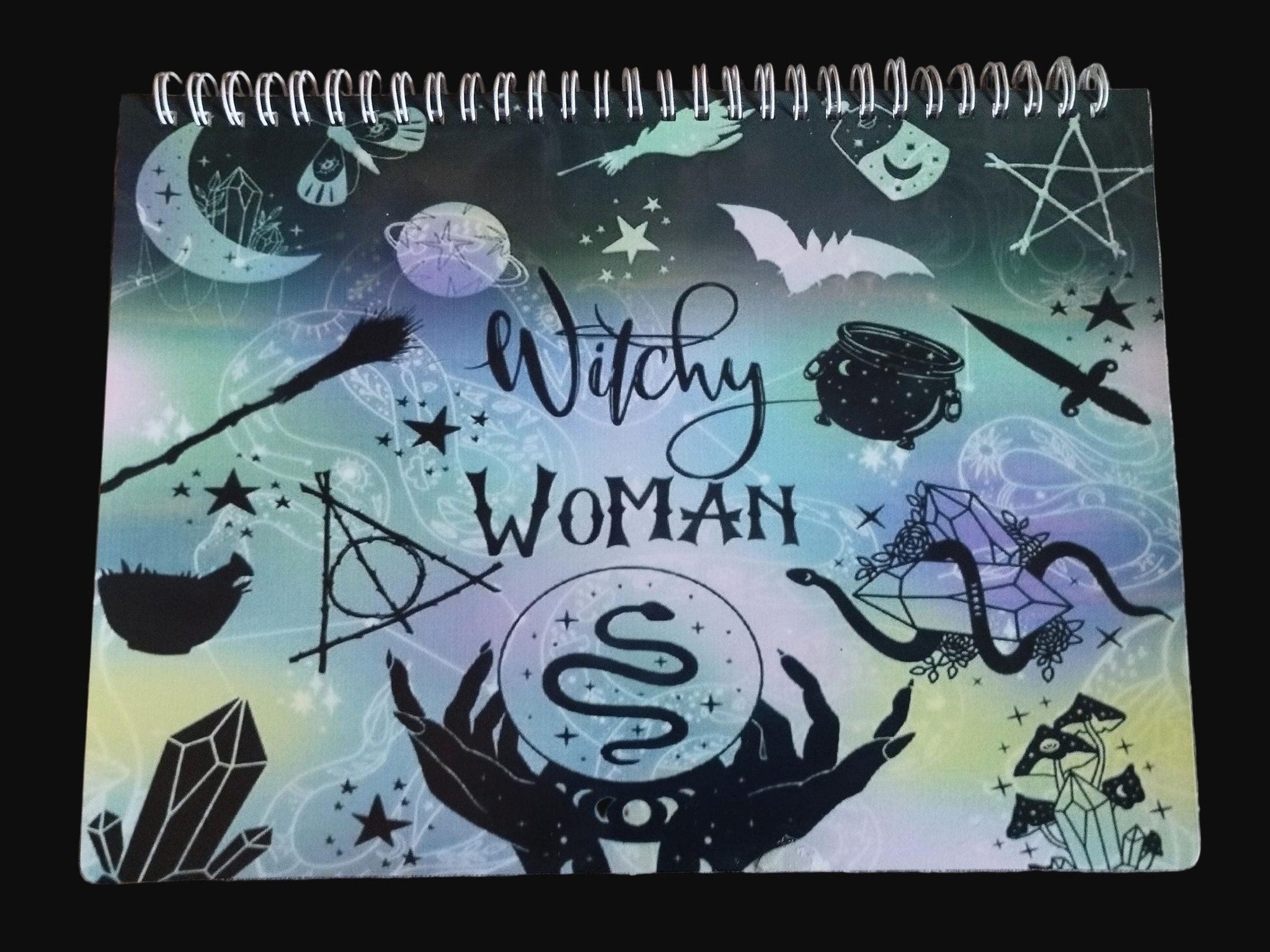Notebook with 'Witchy Woman' design on a wooden surface