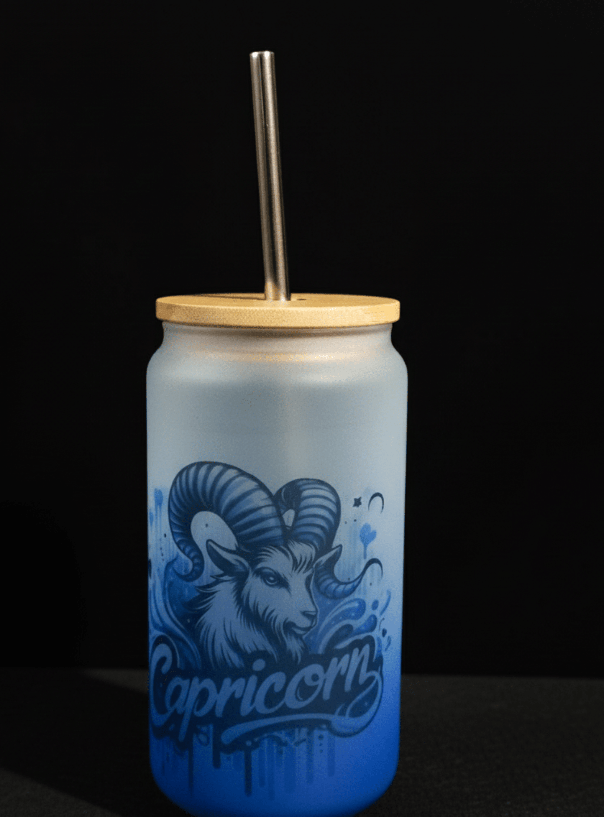 Blue tumbler with Capricorn design and wooden lid on a black background