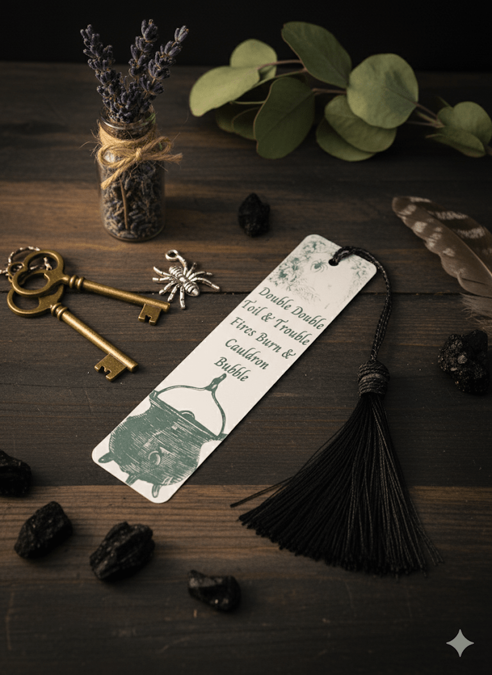 Bookmark with tassel on a wooden surface with keys, lavender, and leaves.
