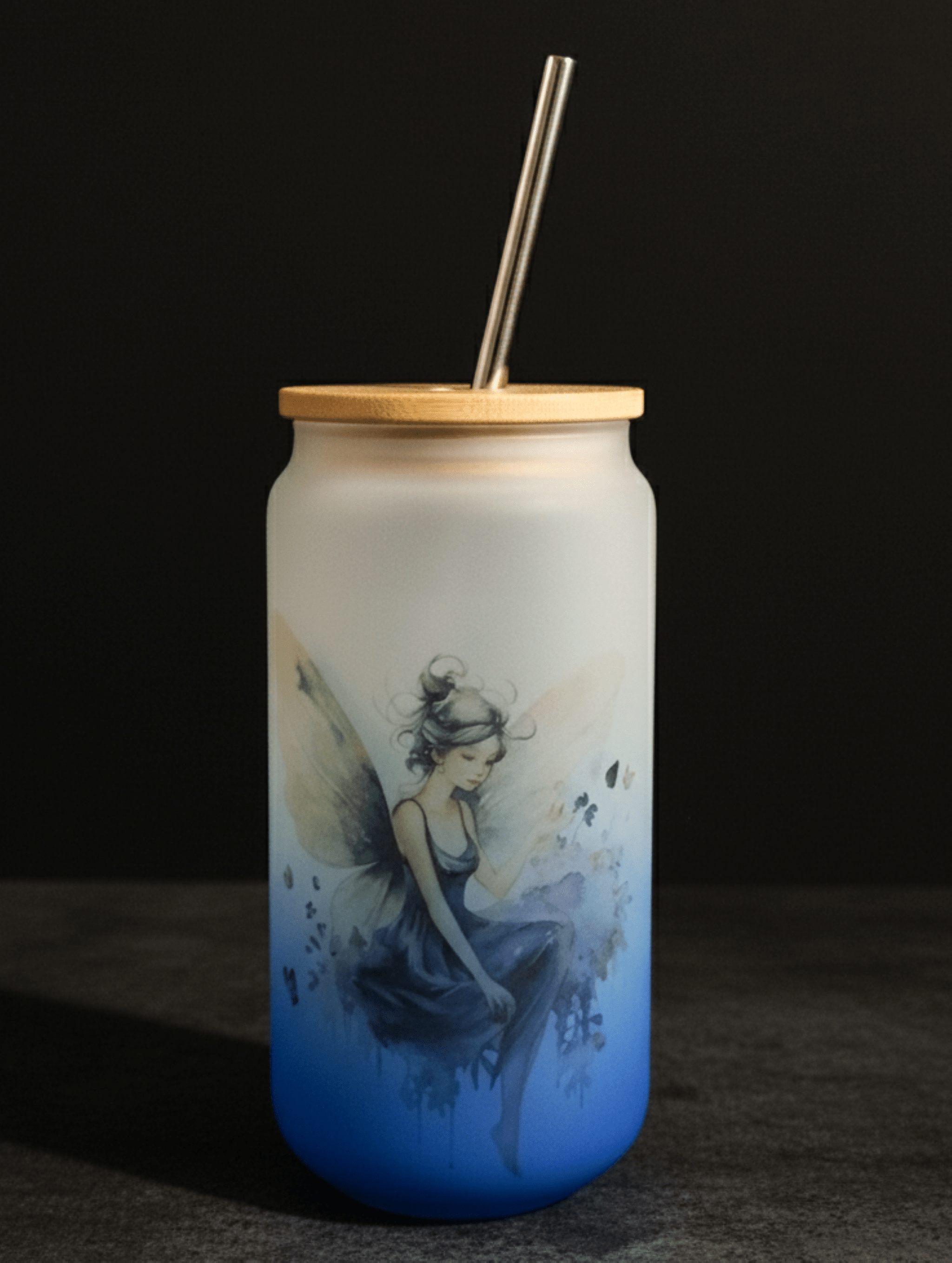 Tumbler with fairy design, wooden lid, and metal straw on a dark background