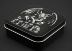 Decorative tin box with a gargoyle design on a dark background