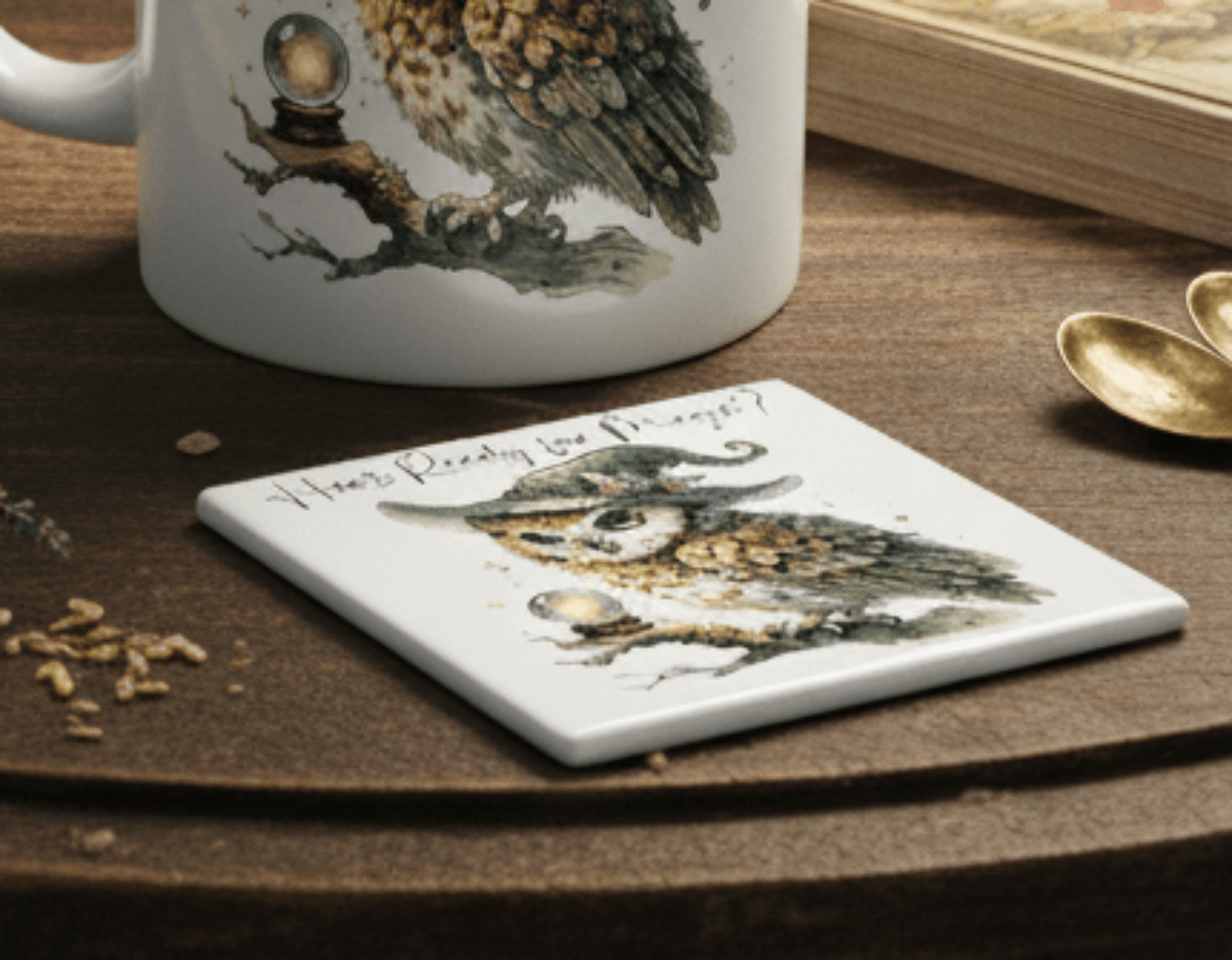 Mug and coaster with owl design on a wooden surface
