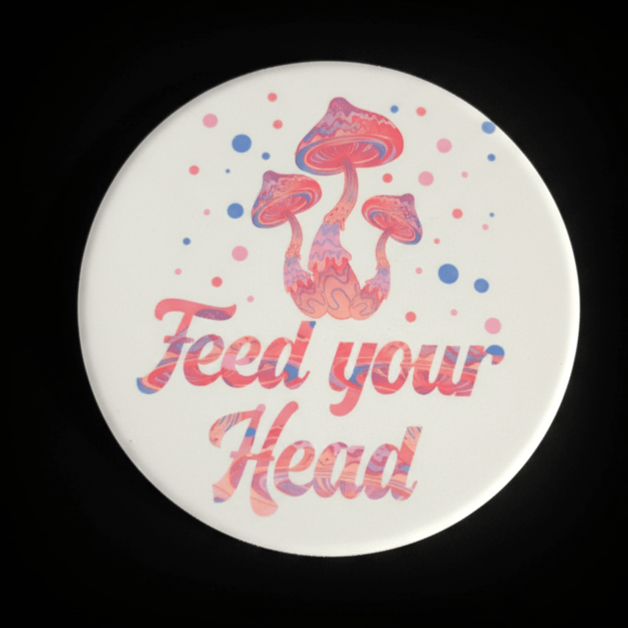 Round ceramic coaster  with mushrooms and 'Feed your Head' text on a black background