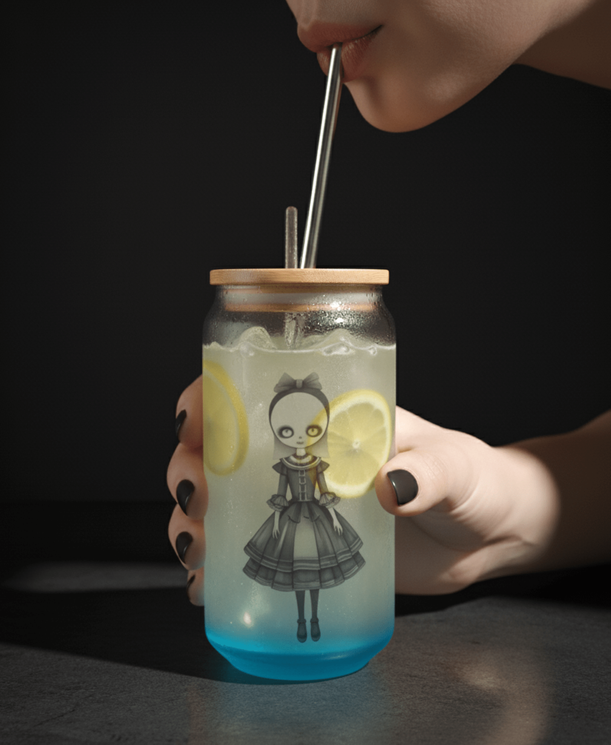 Person holding a jar with a gothic doll, lemon slices, and a straw against a dark background