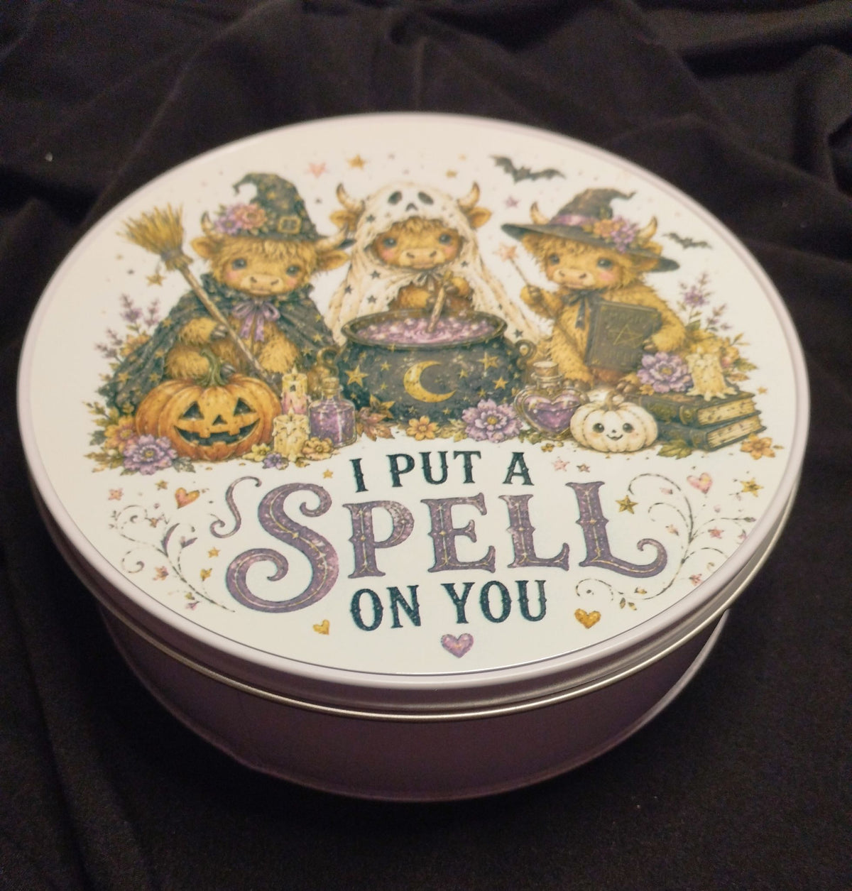 Round tin featuring Halloween Highland cows and the words I Put a Spell on You