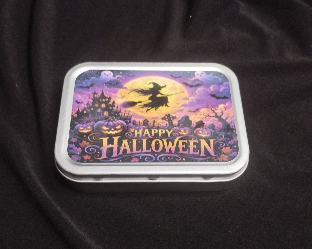 Angled view of a Happy Halloween tobacco and trinket tin with colourful witch and pumpkin artwork