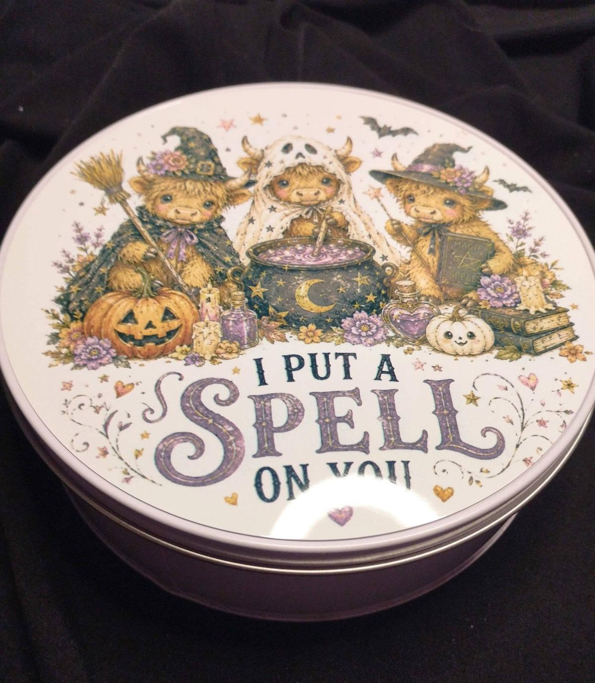 Halloween Highland cow round storage tin showing the decorated lid and metal sides
