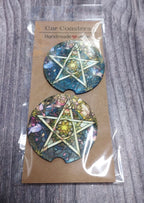 Two car coasters with star designs in packaging on a wooden surface